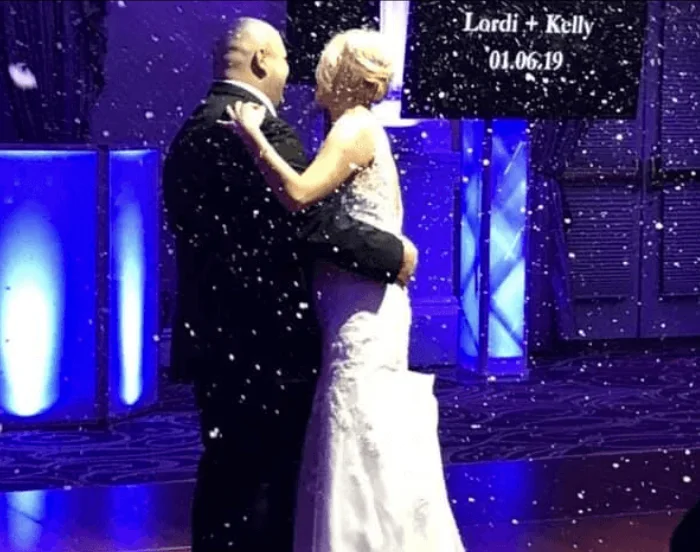 A couple dancing beneath an indoor snowfall effect